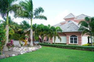 a pink house with palm trees in front of it at Villa Dora Mae in Ocho Rios