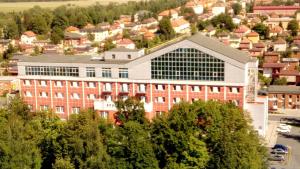a large red brick building in a city at Hotel Spolcentrum in Svit
