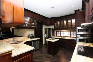 a kitchen with wooden cabinets and stainless steel appliances at Villa Dora Mae in Ocho Rios