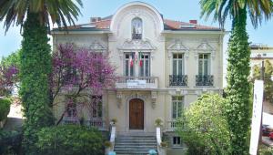 a large house with a flag in front of it at Résidence La Villa Léonie in Nice