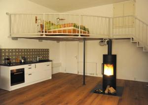 uma cozinha com uma cama alta e um fogão num quarto em Weinloft Staufen em Staufen