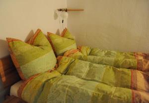 uma cama com um edredão e almofadas em Weinloft Staufen em Staufen