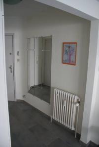 a white room with a mirror and a radiator at Nevada in Koksijde
