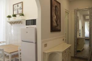 ラ・スペツィアにあるAppartamento Golfo della Luna 2のキッチン(冷蔵庫、テーブル、鏡付)