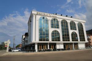 a large white building with large windows on a street at Kubaliç Hotel&SPA in Ordu