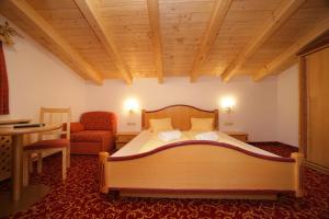sypialnia z łóżkiem, krzesłem i stołem w obiekcie Altachhof Hotel und Ferienanlage - Jokercard im Sommer inklusive w Saalbach Hinterglemm