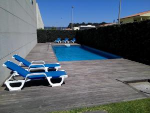 un gruppo di sedie a sdraio accanto alla piscina di T2 Dunas Esposende a Esposende