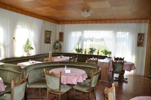 a restaurant with tables and chairs with pink tablecloths at Cafe Best Ferienwohnung in Bullau