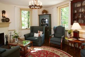 salon z 2 krzesłami i stołem w obiekcie The Zevely Inn w mieście Winston-Salem