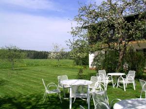 a group of tables and chairs in a yard at Cafe Best Gaestezimmer in Bullau