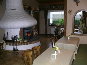 a restaurant with a fireplace and two tables and chairs at Cafe Best Gaestezimmer in Bullau