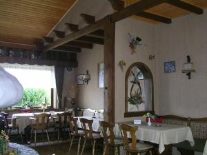 uma sala de jantar com mesas e cadeiras e um espelho em Cafe Best Gaestezimmer em Bullau