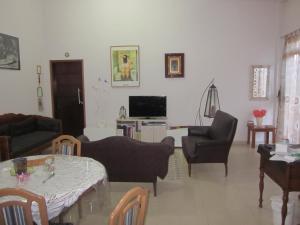 een woonkamer met een tafel en stoelen bij Pousada Chácara Famille Brun in São João da Boa Vista