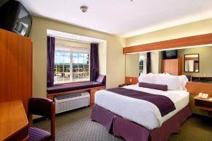 a hotel room with a large bed and a window at Stay Beyond Inn & Suites in Elma