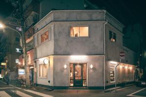 a building on the corner of a street at night at 36hostel in Hiroshima