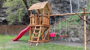 プライドにあるAmalia Vendégházのはしごと滑り台付きの木造遊び場