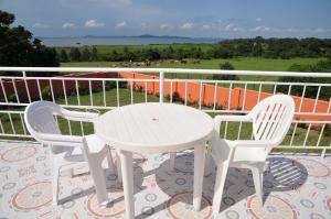 a white table and two chairs on a balcony at Victoria Lake View Guesthouse & Safaris in Entebbe
