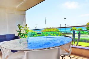 Cette chambre dispose d'un balcon avec une table et des chaises bleues. dans l'établissement Complex Vicor, à Vilassar de Mar