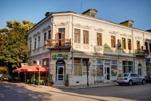 Hotel Izvora في روس: مبنى على شارع فيه سيارة تقف امامه