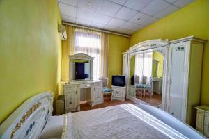 a bedroom with yellow walls and a bed with a mirror at Hotel Izvora in Ruse