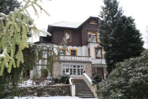 ein großes Haus mit Schnee auf dem Boden in der Unterkunft Ferienhotel Waldfrieden in Bad Sachsa