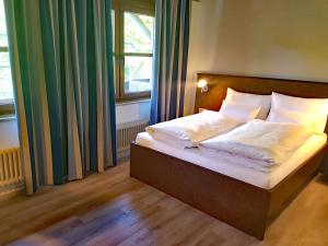 ein Bett mit weißer Bettwäsche und Kissen in einem Schlafzimmer in der Unterkunft Tagungshaus Wernau in Wernau