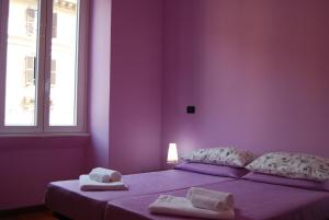 ローマにあるStanze Vaticaneの紫色のベッドルーム(タオル付きのベッド付)