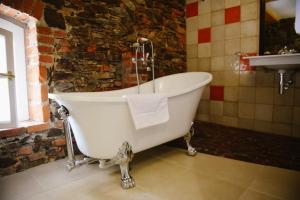 y baño con bañera blanca y lavamanos. en Savoia Castle, en Škvorec