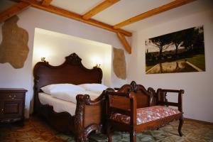 1 dormitorio con cama de madera y silla en Savoia Castle, en Škvorec