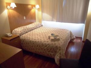 ein Hotelzimmer mit 2 Betten und einem Telefon in der Unterkunft Juramento de Lealtad Townhouse Hotel in Buenos Aires