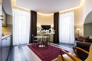 a living room with a table and chairs and a couch at Vino e Oli Residenze in Rome