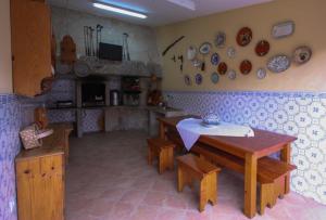 una cucina con tavolo e piatti appesi al muro di Quinta da Toural a Arcos de Valdevez