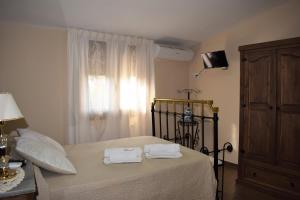 1 dormitorio con 1 cama con 2 toallas en Casa Rural Casa Queta, en Palomero