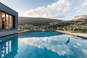 una piscina con vista sulla città e sulle montagne di Rainell Dolomites Retreat a Ortisei