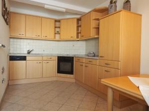 cocina con armarios de madera y encimera en Ferienwohnung Herbst, en Edelsfeld