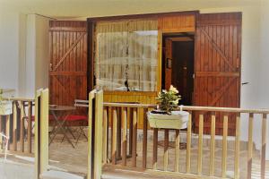 eine Veranda mit einer Holztür und einem Tisch mit einer Pflanze in der Unterkunft La Maisonette in Sauze dʼOulx