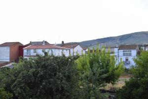 un grupo de edificios con árboles en primer plano en Casa Rural Casa Queta, en Palomero
