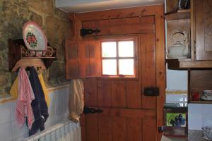 a kitchen with a wooden door and a window at Chou da Covinha in Arrimal