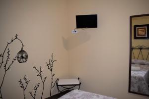 Pokój z łóżkiem, lustrem i telewizorem w obiekcie Casa Rural Casa Queta w mieście Palomero