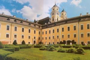 a large building with a garden and a clock tower at Wohnung Schloss Mondsee in Mondsee