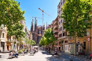 Une rue urbaine animée avec des gens assis sur des bancs dans l'établissement Tendency Sagrada Familia Deluxe, à Barcelone