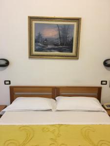 two beds in a bedroom with a picture on the wall at Hotel Dora in Turin