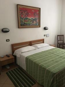 a bedroom with a bed with a green and white blanket at Hotel Dora in Turin