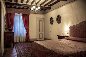 Un dormitorio con una cama grande y una ventana. en Fattoria Guicciardini, en San Gimignano