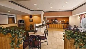 a lobby with tables and chairs and a kitchen at Americas Best Value Inn Waukegan in Waukegan