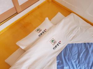 a bed with white pillows on top of it at Jukheon Traditional House in Andong