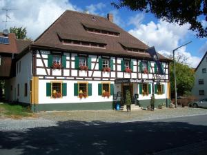 a building with green shutters and flowers on the windows at Landhotel Rangau Gasthof & Brennerei in Markt Erlbach
