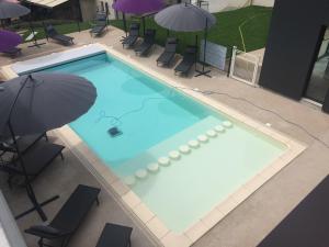an overhead view of a swimming pool with an umbrella at Logis Hôtel et Spa Chez Camillou in Aumont-Aubrac