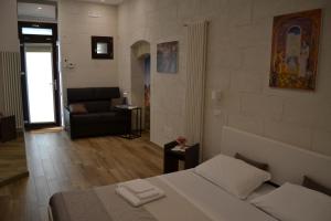 マテーラにあるDimora dell'Annunziataのベッドルーム1室(ベッド1台付)、リビングルーム(ソファ付)