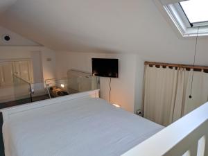 チェルヴェーテリにあるLa Locandinaのベッドルーム(白いベッド1台、薄型テレビ付)